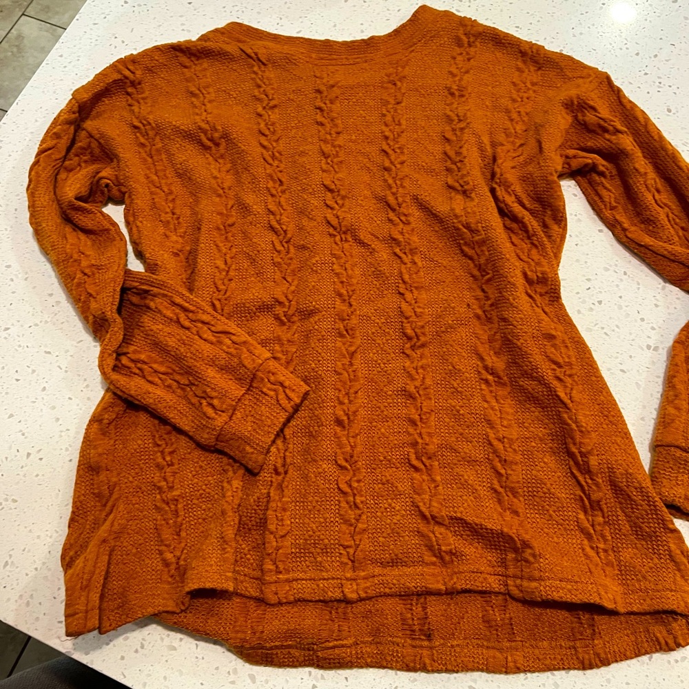 Rust colored cable knit sweater with decorative buttons down back